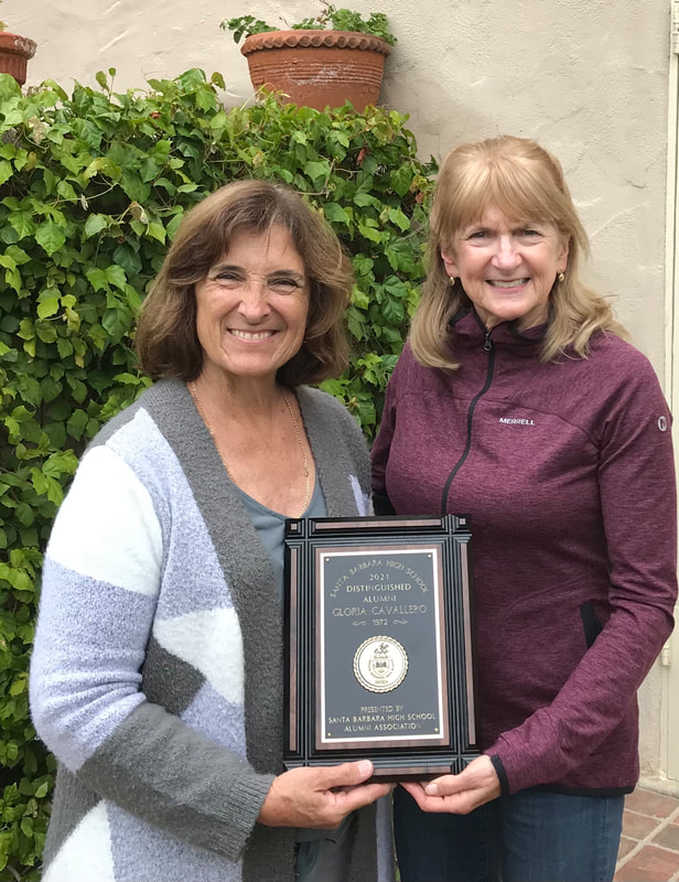 2 women and the Distinguished Alum plaque